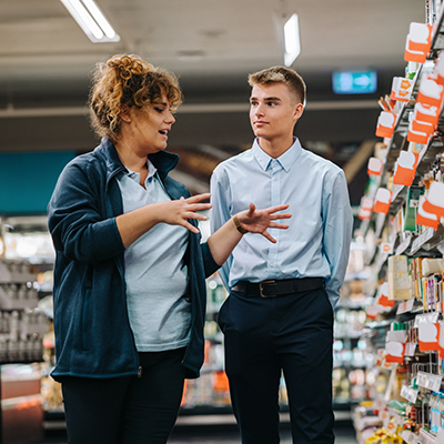 Supermarket manager giving training to a trainee